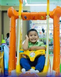 a kid enjoying on a swing at kids zone at city centre nepal